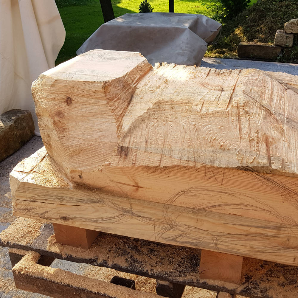 Erste Bearbeitungsphase einer Holzskulptur: Die Froschform wurde grob aus dem Holzblock herausgesägt.