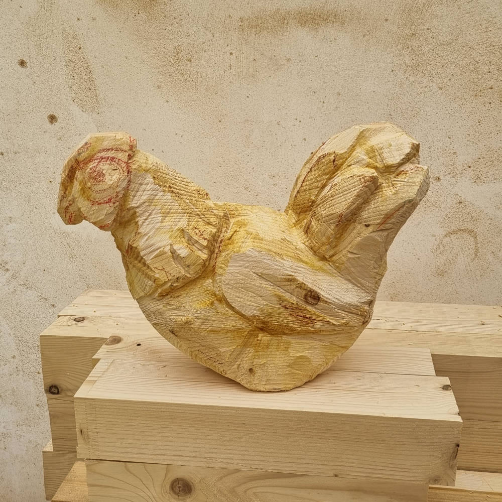 Weiter ausgearbeitete Hühnerskulptur aus Holz mit verfeinerten Formen und Details.