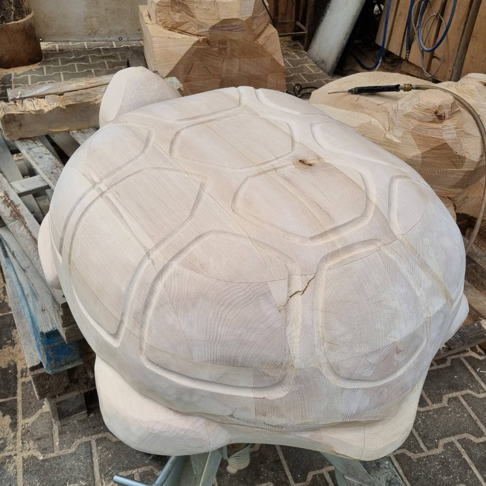 Rückansicht einer weiter ausgearbeiteten Schildkrötenskulptur aus Holz mit detailliert gestaltetem Panzer.
