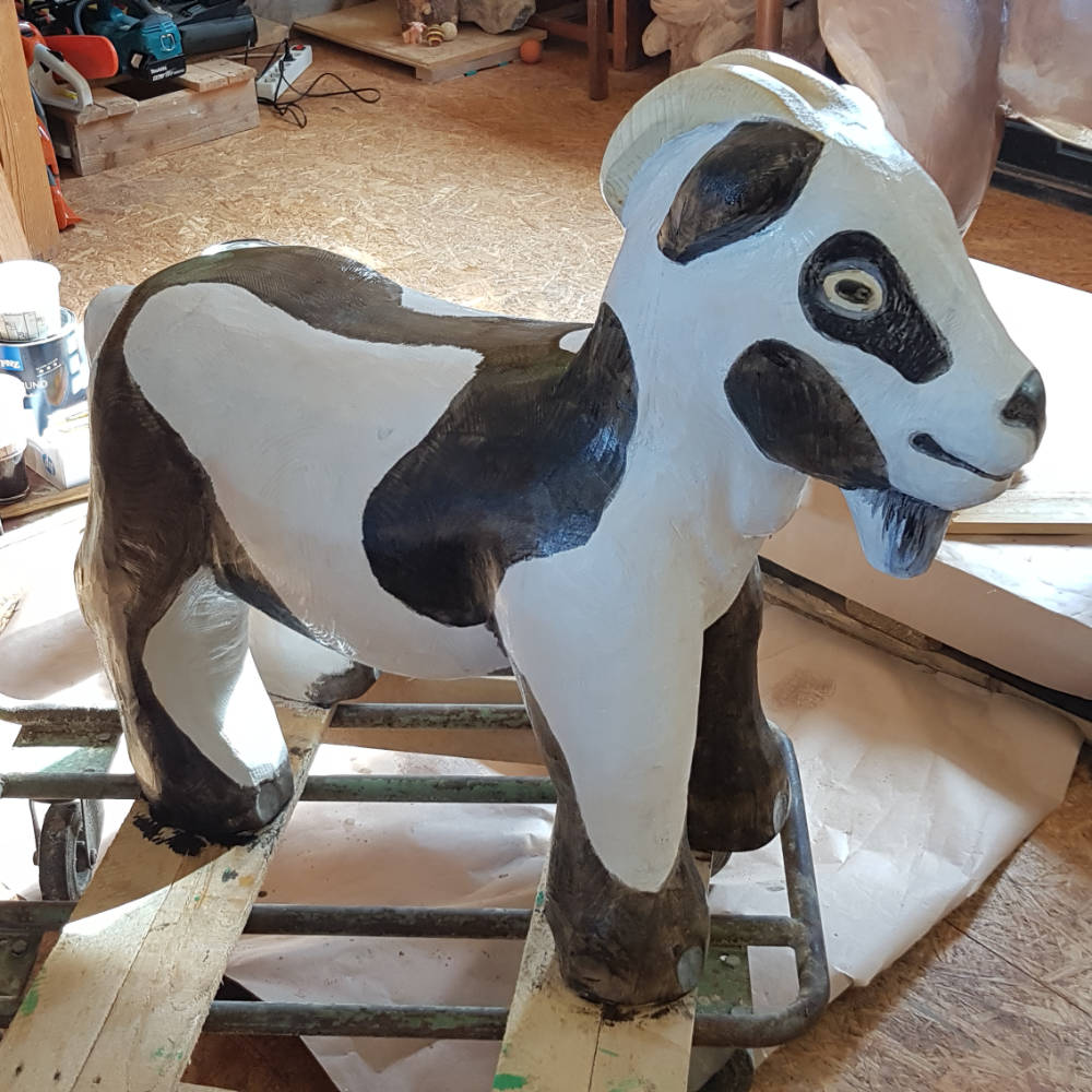 Bemalte Ziegenskulptur aus Holz in der Werkstatt.