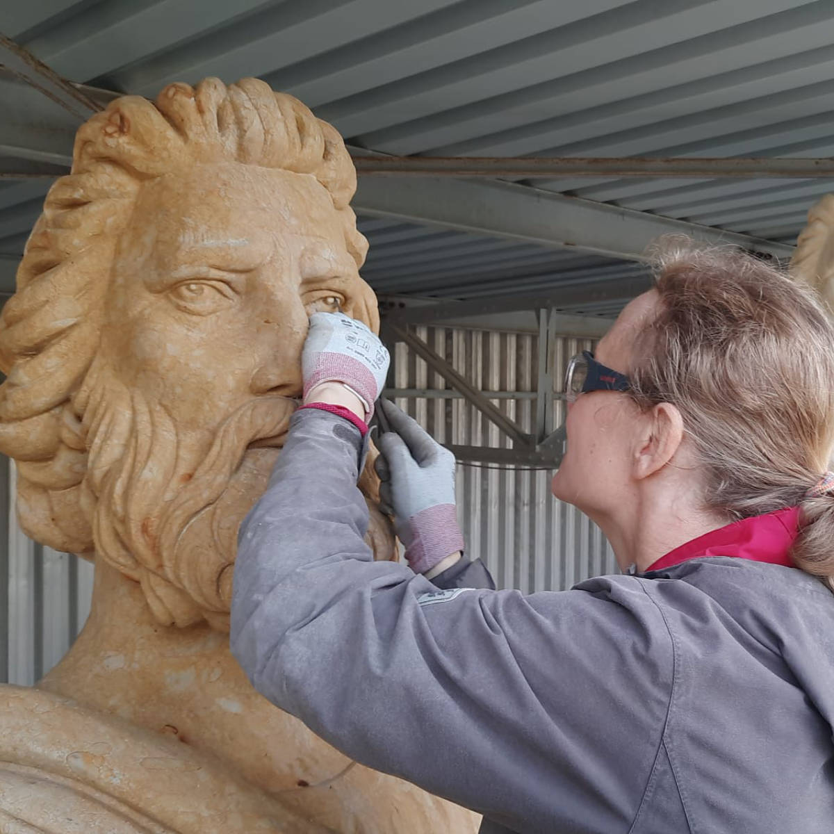 Juliane Uebe führt Feinarbeiten am Gesicht der Sandsteinstatue des Propheten Hosea aus.