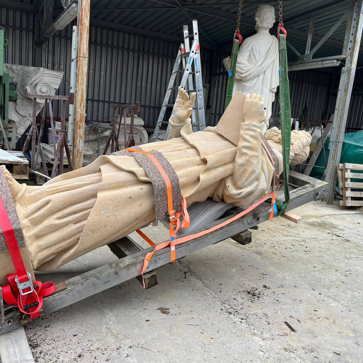 Beginn des Transports der Sandsteinstatue des Propheten Hosea: Die auf dem Rücken liegende Skulptur wird für den Transport angehoben.